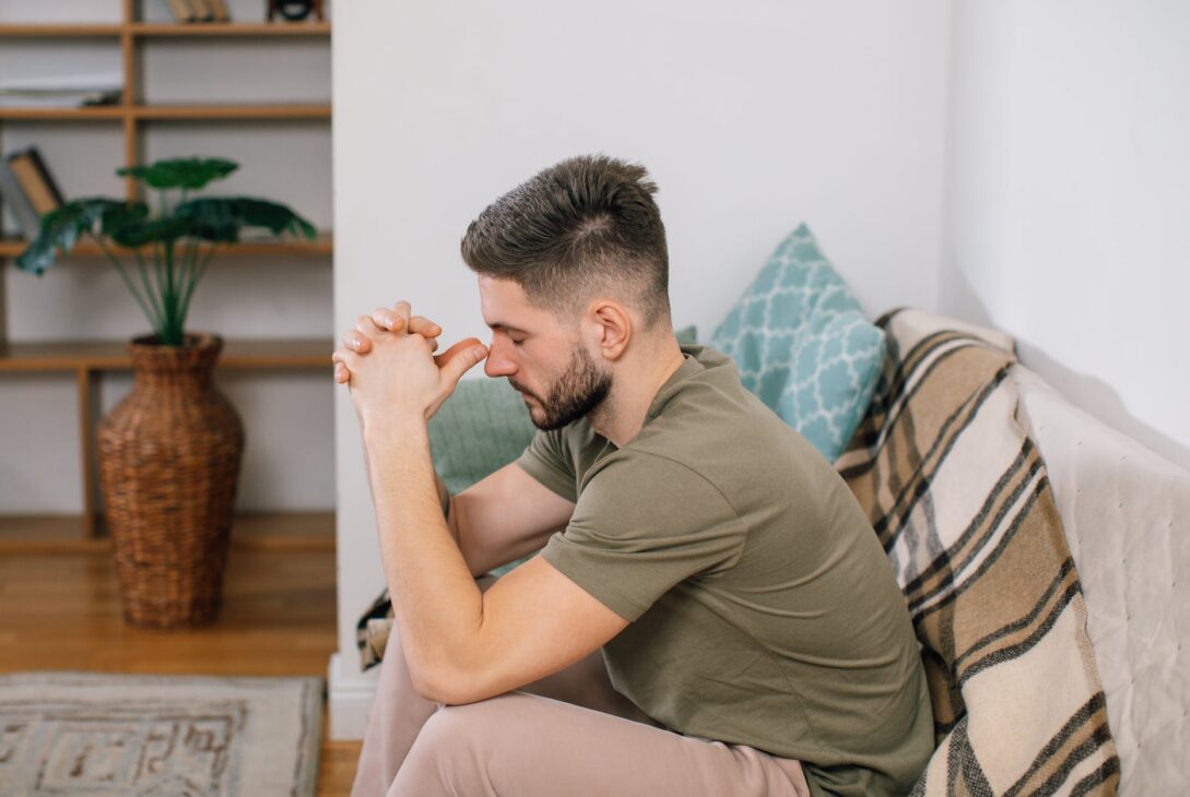 Repentance. A man sitting on a sofa while his hands are together. Repentance.Lacroixmavie.com. Le Message de la croix.LCMV