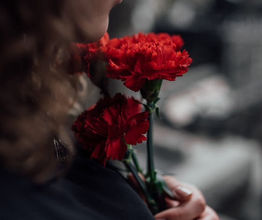 woman holding red flowers.Le lendemain,Lacroixmavie.com EdenDimension.LCMV