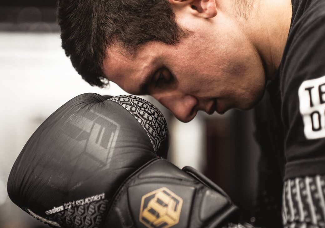 man looking down wearing boxing gloves