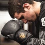 man looking down wearing boxing gloves