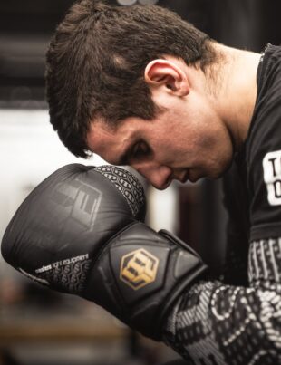 man looking down wearing boxing gloves