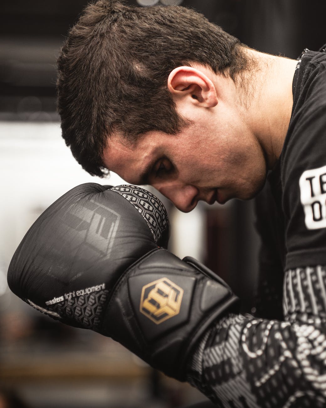man looking down wearing boxing gloves