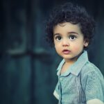 toddle wearing gray button collared shirt with curly hair