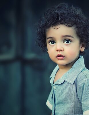 toddle wearing gray button collared shirt with curly hair