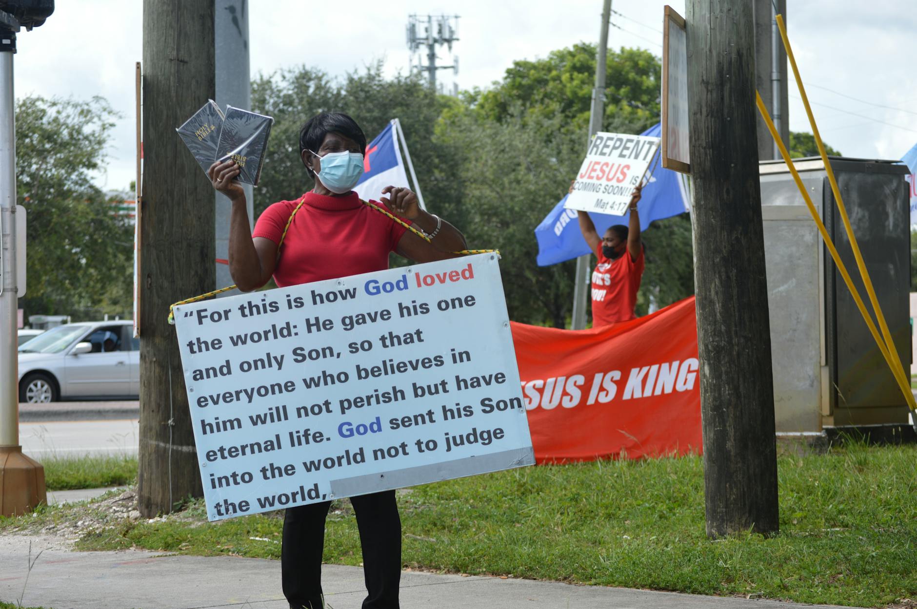 woman in medical mask and board with script on street