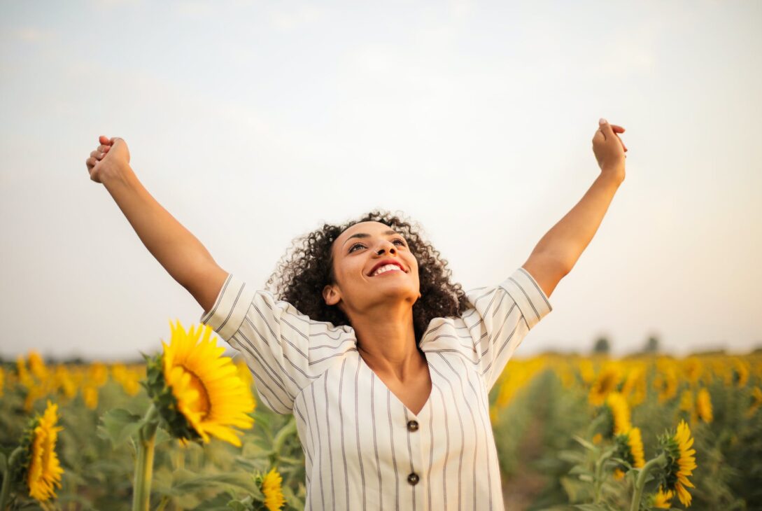 photo of woman standing on sunflower field