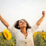 photo of woman standing on sunflower field