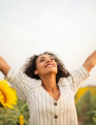 photo of woman standing on sunflower field