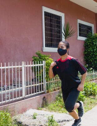 photo of woman jogging beside building during daytime