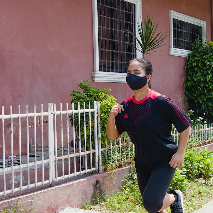 photo of woman jogging beside building during daytime