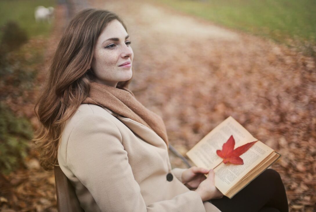 young woman with book in autumn park