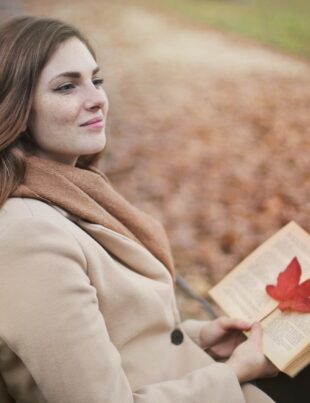 young woman with book in autumn park